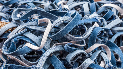 A pile of denim strips, showcasing the texture and color variations of recycled denim material scraps textile