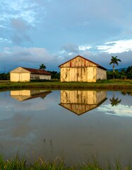 Obraz premium Rural buildings reflected in calm water