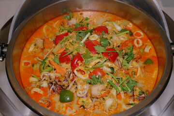 A Culinary Delight: A top-down shot of a gourmet seafood curry presented in a metallic bowl, offering a tantalizing visual experience.