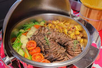 Delicious Buffet: A lavish buffet spread, showcasing an array of culinary delights including succulent grilled meat, roasted vegetables, and golden potatoes, tempting the senses.