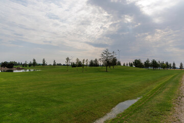 Green Golf Course with Distant Pond