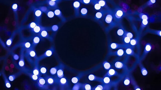 Mystical circular frame of glowing blue and purple bokeh lights with a dark central copy space