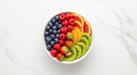 A vibrant and wholesome bowl of assorted fresh fruits, artfully arranged for a healthy breakfast or snack, showcasing nature's colorful bounty on a pristine marble surface.