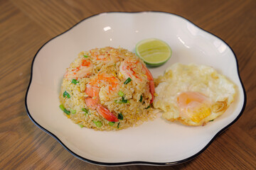 Delicious Shrimp Fried Rice: A culinary masterpiece, showcasing a vibrant serving of shrimp fried rice, complemented by a sunny-side-up egg and a fresh lime wedge, all presented on a stylish plate.