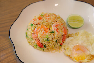 Seafood Fried Rice: An appetizing image of perfectly cooked fried rice studded with succulent shrimp, complemented by a sunny-side-up egg and a slice of lime. A delicious and healthy meal.