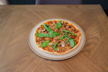 Pizza on Table: A close-up shot captures a delicious pizza, topped with fresh arugula on a wooden table. The pizza is placed in a rustic setting with warm lighting, ready to be enjoyed.