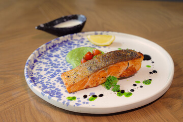 Salmon Gourmet Meal: A delectable serving of grilled salmon, artfully arranged on a patterned plate, adorned with fresh garnishes, creating a visual and culinary delight. 