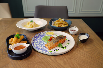Gourmet Delight: A tantalizing shot of a carefully arranged plate of food featuring a slice of grilled salmon, alongside other delicious dishes, promising a flavor-filled experience.