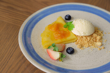 Delectable Crepe Delight: A culinary masterpiece, the crepe, adorned with a vibrant fruit compote, stands as the centerpiece, complemented by a scoop of ice cream and crunchy crumble.