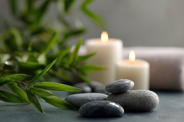 Obraz premium Serene spa environment with smooth stones, candles, and bamboo plants creating a relaxing ambiance