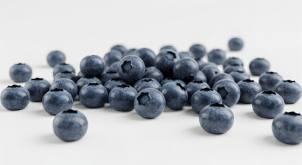 A close-up, high-angle shot of a pile of fresh, ripe blueberries scattered on a white surface.