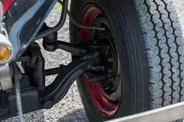 A detailed, close-up shot of the front axle, drum brake, and suspension components on a classic AA or BB truck