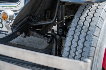 A detailed, close-up shot of the front axle, suspension, and transverse leaf springs on a classic type AA or BB truck
