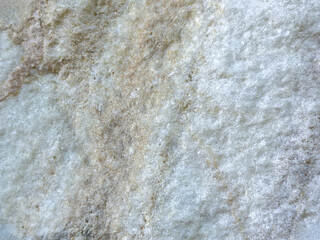 Close-up texture of rough beige white stone surface with natural patterns