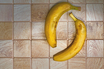 Couple relation.Two ripe bananas on checkered wooden surface