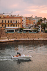 Traditional architecture of Taranto old town with the sea and boats during summer sunset.