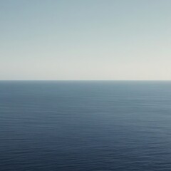 Obraz premium Minimalist wallpaper of an endless ocean horizon stretching into the distance under a clear blue sky, symbolizing freedom, open space, and the beauty of simplicity.