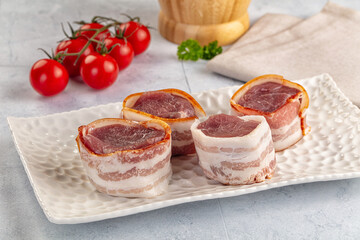 Raw pork tenferloin with bacon