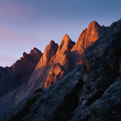 Obraz premium sunrise over mountain peaks, warm glow on rocky cliffs