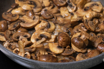 sliced mushrooms and onions sizzling in a hot pan