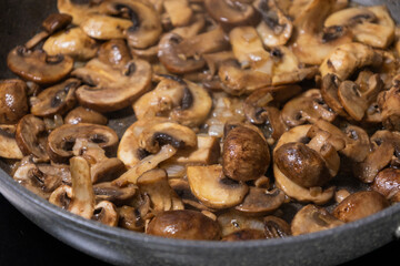 sliced mushrooms and onions sizzling in a hot pan