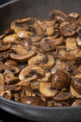 sliced mushrooms and onions sizzling in a hot pan