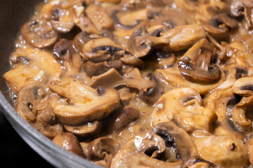 creamy mushroom sauce simmering in a pan with sautéed mushrooms and onions