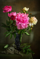 Still life with a bouquet of beautiful peonies in a glass vase.