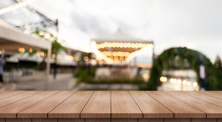Empty wooden table top with lights bokeh on blur restaurant background.	