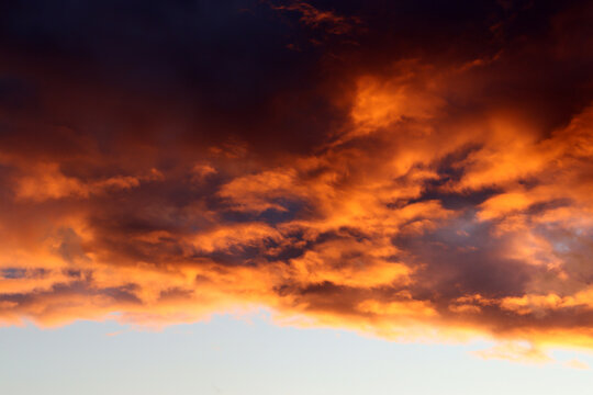 Evening sky, thunderclouds illuminated in orange by the sun (Breisach, Germany)