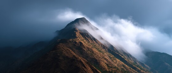mountain peak with clouds rolling over valleys, dramatic lighting
