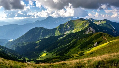 Obraz premium Lush green mountains and valleys stretch under a dramatic sky, showcasing the beauty of a high-altitude vista.