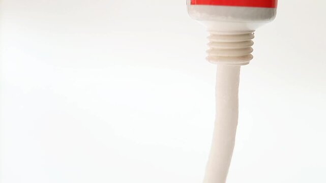 White cream coming out of a tube on white background, medical, cosmetic or skincare product