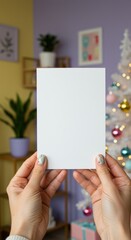 Obraz premium Woman holding a blank vertical white card mockup against a festive Christmas background, ideal for holiday greeting card design or New Year invitation.