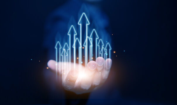 Glowing upward arrows rising from a hand, symbolizing business growth, success, leadership, financial progress, innovation, and digital technology development.