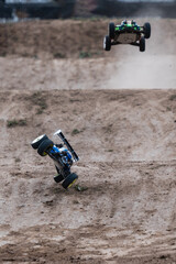 Radio-controlled cars jumping and crashing on dirt track © Zoran Jesic
