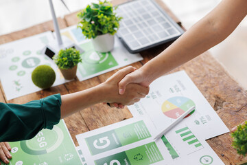Close up of business people shaking hands over ESG strategic commitment workshop, SDGs report,...