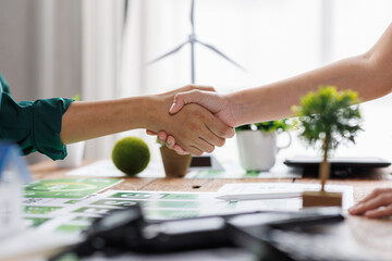 Close up of business people shaking hands over ESG strategic commitment workshop, SDGs report, global warming, green finance investment eco friendly and net zero waste in boardroom training building.
