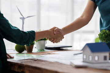 Close up of business people shaking hands over ESG strategic commitment workshop, SDGs report, global warming, green finance investment eco friendly and net zero waste in boardroom training building.
