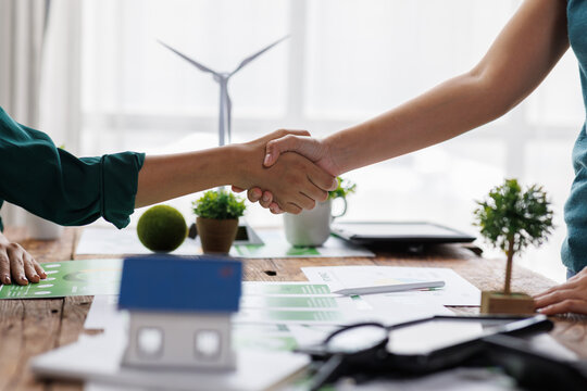 Close up of business people shaking hands over ESG strategic commitment workshop, SDGs report, global warming, green finance investment eco friendly and net zero waste in boardroom training building.
