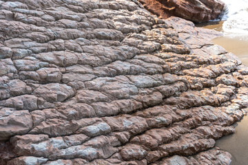 Layered rocks, flysch texture background. Sedimentary rock, striations stone pattern