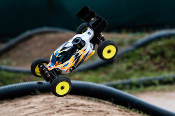 Radio-controlled car jumping on a dirt track during a race