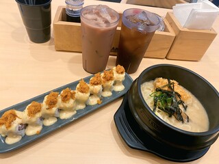 Japanese Food Set with Sushi Roll, Ramen, and Iced Drinks on Table
