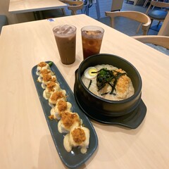 Japanese Food Set with Sushi Roll, Ramen, and Iced Drinks on Table
