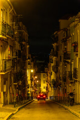 A car at night in the narrow streets of Lisbon