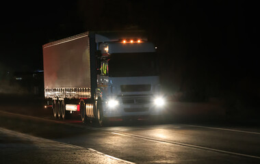 truck drives along a night road