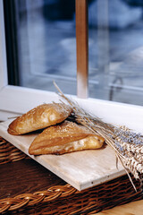 Freshly baked artisan bread and golden wheat displayed beautifully on a wooden board