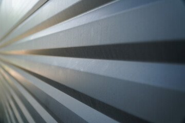 Dynamic angled perspective of a corrugated silver metal sheet, showcasing parallel lines and a...