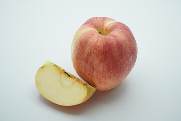 A crisp red and yellow apple with a freshly cut slice isolated on a plain white background, symbolizing healthy eating, nutrition, and natural food