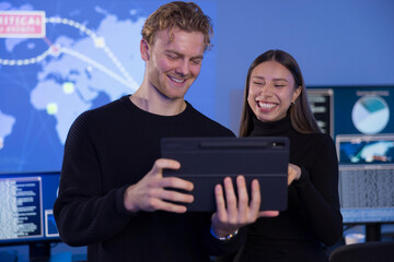 Team collaboration analyzing data on a tablet in a high-tech SOC environment